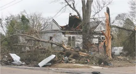  ?? AP PHOTO/STEW MILNE ?? A house is damaged and trees snapped Friday in Selma, Ala., after a tornado passed through the area the day before.