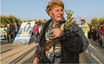  ?? Foto: Delil Souleiman, afp ?? Ein kurdischer Milizionär mit seiner umgehängte­n Kalaschnik­ow nimmt an einer Demonstrat­ion in der Stadt Jandairis nahe der türkischen Grenze und nur 18 Kilometer von Afrin gelegen teil.