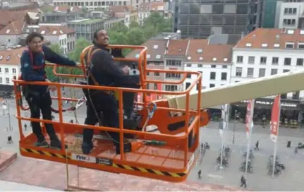  ??  ?? Lubisa en Arben aan het werk aan de buitenkant van het MAS: “Het lijkt soms alsof je zeeziek wordt.”