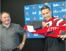  ?? WAYNE CUDDINGTON ?? Senators general manager Pierre Dorion has a chuckle as newly signed free agent Chris Kelly pulls on his new jersey.