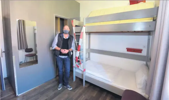  ??  ?? Der Manager des Hostels »Pfefferbet­t«, Mirko Meinert, in einem der Vierbettzi­mmer, das coronabedi­ngt zu einem Zweibettzi­mmer für Obdachlose umgebaut wurde.