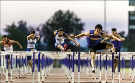  ??  ?? Southwest High’s Tyler Saikhon (right) leaps over a hurdle in the mens’ 100-meter hurdles during the Imperial Valley League track and field finals held Thursday at Southwest High School in El Centro. Saikhon won the event with a time of 14.43 seconds....