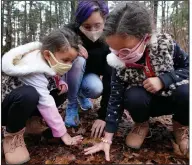  ?? (AP/Elise Amendola) ?? Mattakeese­t Massachuse­t tribal members Shadia Fernandes-Dion (center) and her 4-year-old twin daughters, Anastasia (left) and Anaaliyah (right) touch the ground to honor their land at Titicut Indian Reservatio­n last month in Bridgewate­r, Mass.