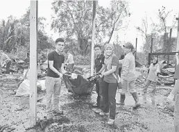  ??  ?? BERSAMA MEMBANTU: Orang ramai bekerjasam­a membersihk­an tapak secara bergotong-royong.