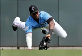  ?? JEFF ROBERSON ?? FILE - In this Friday, March 1, 2019 file photo, Miami Marlins center fielder Lewis Brinson dives to catch a fly ball by Washington Nationals’ Adam Eaton for an out during the third inning of an exhibition spring training baseball game in Jupiter, Fla. A five-person panel of Major League Baseball players, coaches and executives discussed ways to get more Black people involved at all levels of the sport. Lewis Brinson was on the panel.