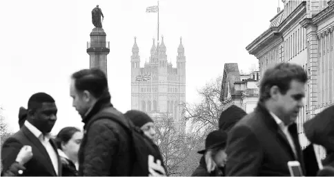  ?? — AFP photo ?? Union flags fly above and in front of Britain’s Houses of Parliament as pedestrian­s walk across a busy road in central London. Britain will trigger its exit from the European Union on Mar 29.