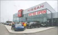  ?? NEWS PHOTO RYAN MCCRACKEN ?? The staff at Medicine Hat Nissan stand outside the dealership’s new location on Strachan Road on Monday.