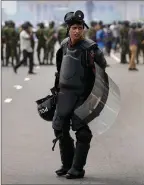  ?? ?? The Associated Press
A Sri Lankan policeman stands guard in riot gear during clashes in Colombo, Monday.