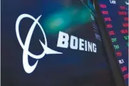  ?? AP PHOTO/RICHARD DREW ?? The logo for Boeing appears on a screen above a trading post in 2021 on the floor of the New York Stock Exchange.