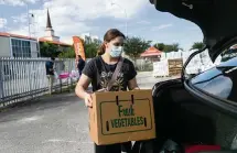  ?? MATIAS J. OCNER mocner@miamiheral­d.com ?? Sophia Brito-Travieso, 12, loads up a vehicle during a drive-thru food distributi­on event in Hialeah on Saturday, December 5, 2020.