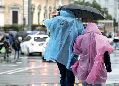  ?? (foto Claudio Guaitoli) ?? Due turisti in piazza dei Cinquecent­o provano a ripararsi dalla pioggia