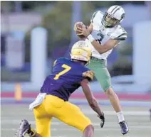  ?? MICHAEL LAUGHLIN/SUN SENTINEL ?? Miami Central’s Anthony Fedrick catches a pass in front of St. Thomas Aquinas’ Jordan Battle during the first half.