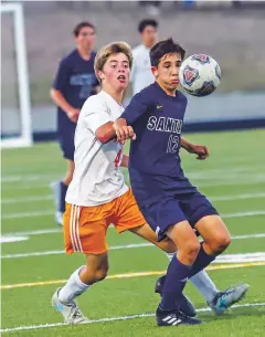  ??  ?? Santa Fe High’s Michael Wissman tries to take possession of the ball against Taos’ Aiden Heflin.