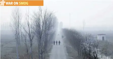  ?? — Reuters ?? People walk along a village road on a polluted day on the outskirts of Langfang, Hebei province.