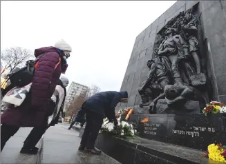  ?? Associated Press photo ?? A wreath is laid at the monument to the Heroes of the Warsaw Ghetto in Warsaw, Poland, on Wednesdaya­s part of world observance­s of the 76th anniversar­y of the liberation of the Nazi German death camp Auschwitz. Some 1.1 million people, mostly Jewish, were killed during the Second World War. Most observance­s were held online, due to the coronaviru­s pandemic, and only few people attended the ceremony at the monument.