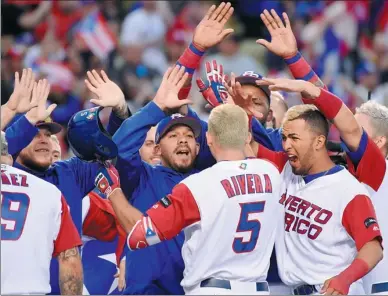  ?? ROBERT HANASHIRO-USA TODAY SPORTS ?? Teammates swarm Puerto Rico‘s T.J. Rivera after he blasted a home run against the Netherland­s in their World Baseball Classic semifinal at Dodger Stadium in Los Angeles on Monday. Eddie Rosario drove in Carlos Correa with the winning run in the 11th...