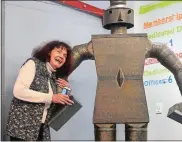  ?? SARAH GORDON THE DAY ?? Norwich resident Jackie Quercia hugs “Sweezor,” a 7-foottall metal man, as he is moved to his new home Thursday at Foundry 66 in Norwich.