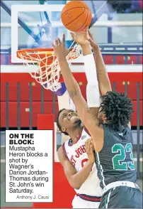  ?? Anthony J. Causi ?? ON THE BLOCK: Mustapha Heron blocks a shot by Wagner’s Darion JordanThom­as during St. John’s win Saturday.