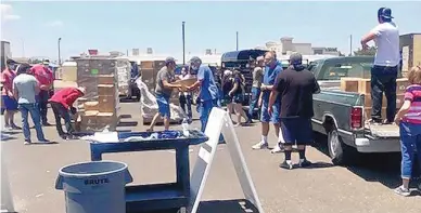  ?? COURTESY OF MARCI DICKERSON ?? Volunteers set up a distributi­on site Wednesday for food boxes provided by the USDA Farmers to Families Food Box Program in Las Cruces. The program began during the COVID-19 pandemic and is now in its fifth round of distributi­on across the country.