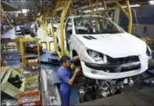  ?? EBRAHIM NOROOZI — THE ASSOCIATED PRESS FILE ?? In this file photo, an Iranian worker assembles a Peugeot 206 at the state-run Iran-Khodro automobile manufactur­ing plant near Tehran, Iran. From brand-new airplanes to oilfields, billions of dollars of deals stand on the line for internatio­nal...