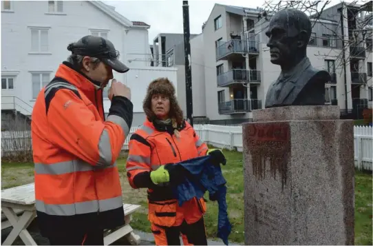  ??  ?? SKJØNNER DET IKKE: Verken anleggsgar­tner Thorbjørn Knudsen eller Anita Christense­n i parkvesene­t skjønner hvorfor noen har tagget «Judas» på G.E. Gundersen statuen. Her lukter Knudsen på stoffet for å prøve å finne ut hva det er.