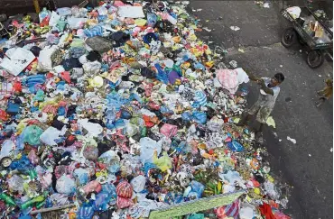  ?? — AFP ?? This file photo taken in June last year shows a Sri Lankan man throwing trash onto garbage piled on a street in Colombo.
Sri Lanka on Sept 1 slapped a blanket ban on the import, manufactur­e or sale of disposable plastic products and polythene shopping...