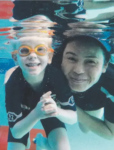  ?? Picture: JUSTIN BRIERTY ?? NO BARRIERS: Swim instructor Kaname Woodfield assists Arlo Groenewege­n, 5, who has cerebral palsy, at the C-Me school, which prides itself on helping people of all abilities.