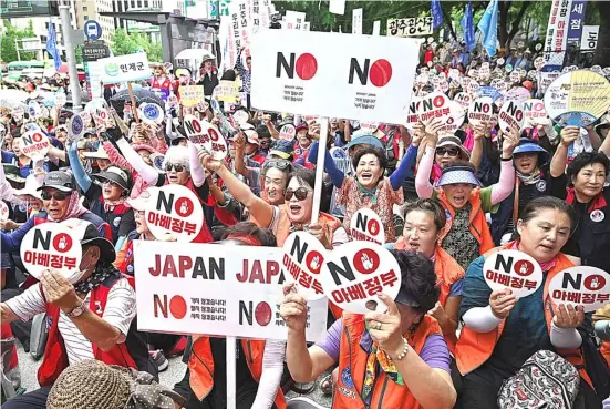  ??  ?? SOUTH Korean protesters hold up signs reading “No Abe’s government” during an anti-Japanese rally in central Seoul.