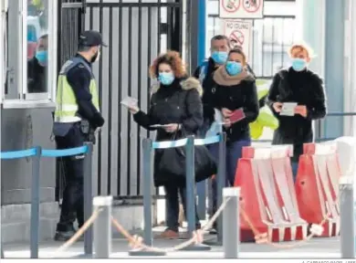  ?? A. CARRASCO RAGEL / EFE ?? Un grupo de españoles muestra su pasaporte a un policía nacional para acceder a Gibraltar.