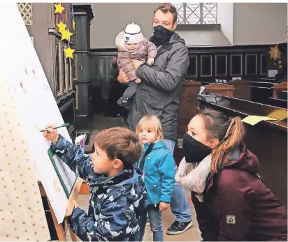  ?? FOTO: DORO SIEWERT ?? An sechs Stationen konnten die Besucher die Weihnachts­geschichte einmal ganz anders erleben. Matthis, Luisa und Marlene besuchten das Gotteshaus mit ihren Eltern Klaus und Tordis Bernshause­n.