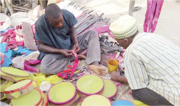  ?? PHOTO ABUBAKAR SADIQ ISAH ?? A leather worker attends to a customer at Gwagwalada market on Monday.