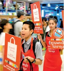  ?? (Photo by Mladen ANTONOV / AFP) ?? Employees carry banners informing customers about the ban on free single-use plastic bags at a shopping mall in downtown Bangkok on January 2, 2020.