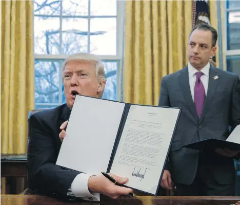  ?? EVAN VUCCI/THE ASSOCIATED PRESS FILES ?? White House chief of staff Reince Priebus, right, looks on as President Donald Trump shows off an executive order last week to withdraw the U.S. from the 12-nation Trans-Pacific Partnershi­p trade pact agreed to under the Obama administra­tion.