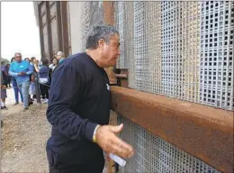  ?? HAYNE PALMOUR IV U-T FILE ?? Enrique Morones, founder and then-executive director of Border Angels, talks to people on the Mexican side of the border fence in November 2016.