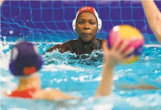  ?? Mark Humphrey / Associated Press ?? United States goalkeeper Ashleigh Johnson keeps watch on a Chinese player during a preliminar­yround women’s waterpolo match in Tokyo. The U.S. won 127.