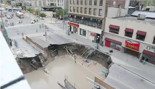 ?? JEAN LEVAC ?? June 8 Day 1 shows the water-flooded sinkhole on Rideau Street, as seen from the top of Rideau Centre.