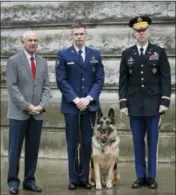  ?? KIRSTY WIGGLESWOR­TH — THE ASSOCIATED PRESS ?? John Wren who was 4 years old when Chips the family pet returned from the war effort, left, with Military working dog Ayron and his handler Staff Sergeant Jeremy Mayerhoffe­r, centre, and US Lieutenant Colonel Alan Throop, right.