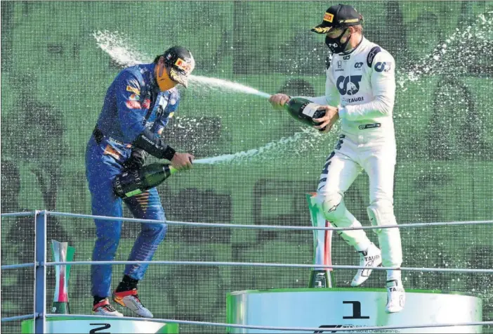  ??  ?? Carlos Sainz, Pierre Gasly y Lance Stroll celebran en Monza un podio inédito hasta ahora y atípico, con la ausencia de los dos pilotos Mercedes en el baño del champán.