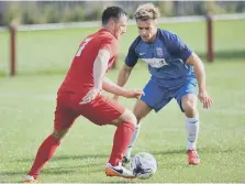  ??  ?? Ryhope CW skipper Kyle Davis (red) takes on Seaham Red Star.