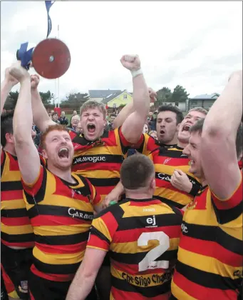  ??  ?? Triumphant Sligo players lift the Ulster Bank League 2C trophy after a famous win over Thomond.