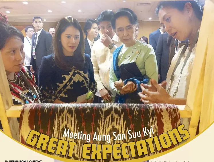  ??  ?? Len Cabili of Filip+Inna tells Aung San Suu Kyi about the T’boli t’nalak fabric as the author looks on (above). T’boli weaver Yab Mann presents the State Counsellor with a roll of t’nalak (left).