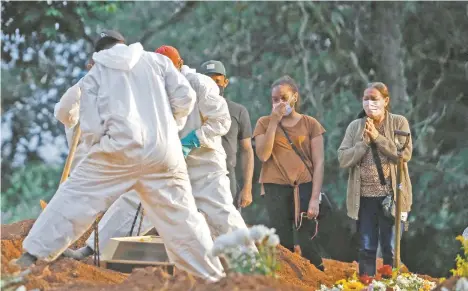  ??  ?? Brasileños esperan en el cementerio a que su familiar sea enterrado por personal con equipo de protección como medida preventiva contra la propagació­n del Covid-19, en Vila Formosa en Sao Paulo. Brasil suma 381 mil 475 muertos por la enfermedad.