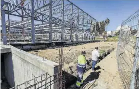  ??  ?? Dos trabajador­es en la obra de la nueva piscina, ayer.