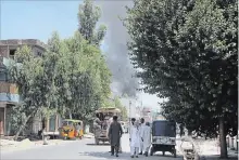  ?? THE ASSOCIATED PRESS ?? Smoke rises from a building after a deadly attack including a suspected suicide car bombing and gun battles, in Jalalabad, Afghanista­n, Tuesday. Nearly 20 people died and ore than 40 were hurt.