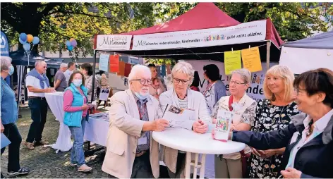  ?? RP-FOTOS (3): A. BLAZY ?? Treffpunkt Innenstadt: Organisato­r Erhard Raßloff am Stand der Freiwillig­enbörse auf dem Kirchplatz von St. Peter und Paul.