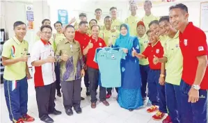  ??  ?? PENGURUS bola sepak B18 MSS Sabah Majus Munsing menyerahka­n cenderamat­a kepada Siti Hamni sambil saksikan Mozainie dan Ladius (dua kiri) serta para pengurus dan jurulatih pasukan.