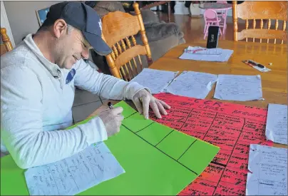  ?? ERIC MCCARTHY/JOURNAL PIONEER ?? Christophe­r Cross resident Malcolm Pitre is matching up donors and song requesters on sheets of bristle board as a means of keeping track of the progress on his Christophe­r Cross Requests Facebook page fundraiser.