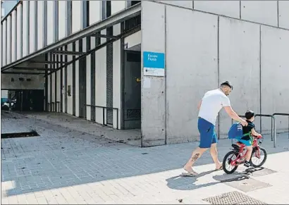  ?? ENRIC FONTCUBERT­A / EFE ?? Un padre y su hijo pasean junto a una escuela en el barrio de Poblenou de Barcelona
