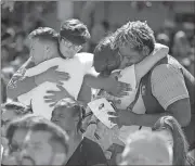  ?? Wilfredo Lee / AP ?? Attendees comfort each other at a prayer vigil for the victims of the shooting at Marjory Stoneman Douglas High School at Parkland Baptist Church on Thursday.