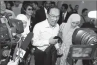  ?? AP ?? Malaysian opposition leader Anwar Ibrahim (center) arrives Tuesday in Putrajaya, Malaysia, for a court appearance on sodomy charges.